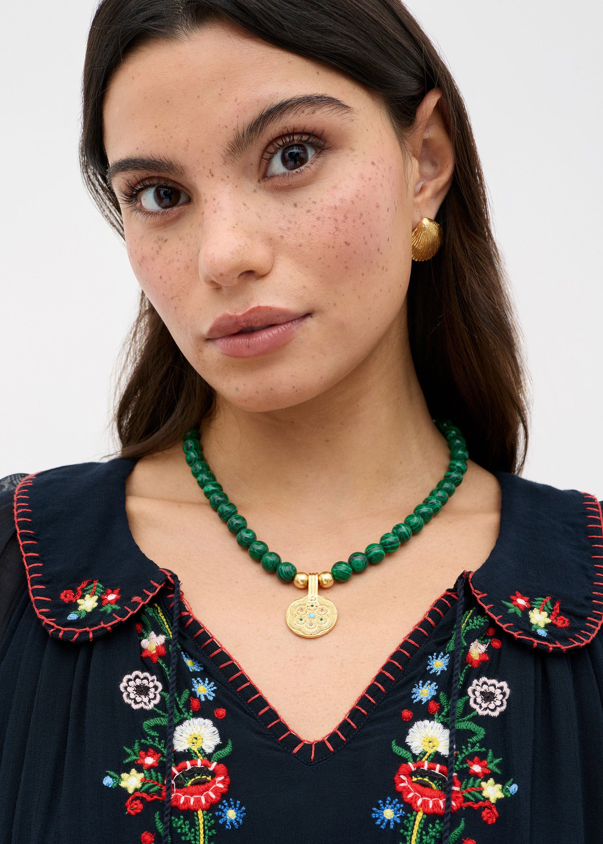 Rixo Styled with a navy embroidered peasant top and gold disc earrings