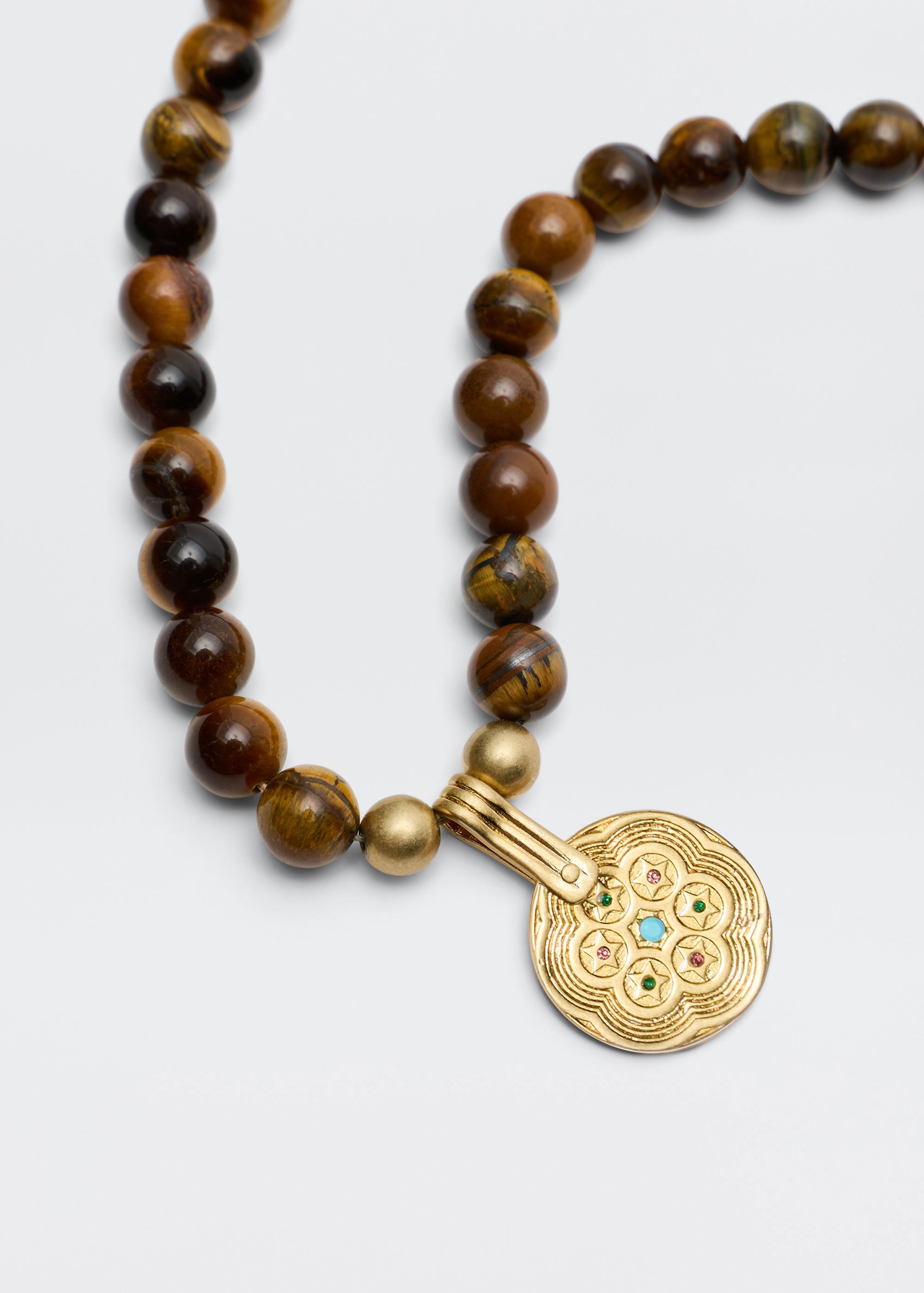 Rixo Close-up of the gold-plated medallion with star and gemstone detailing