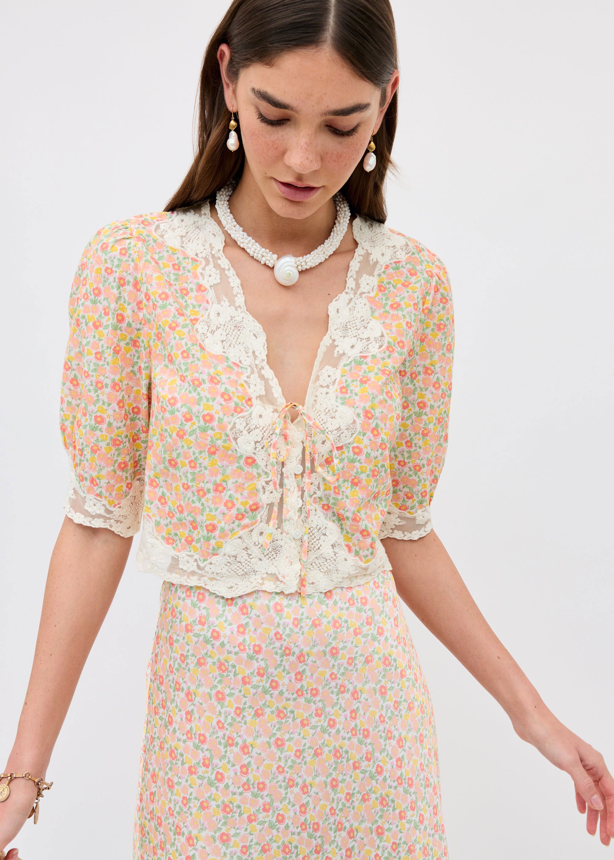 Rixo Close-up of the bodice with scalloped lace V-neck and corded tie front