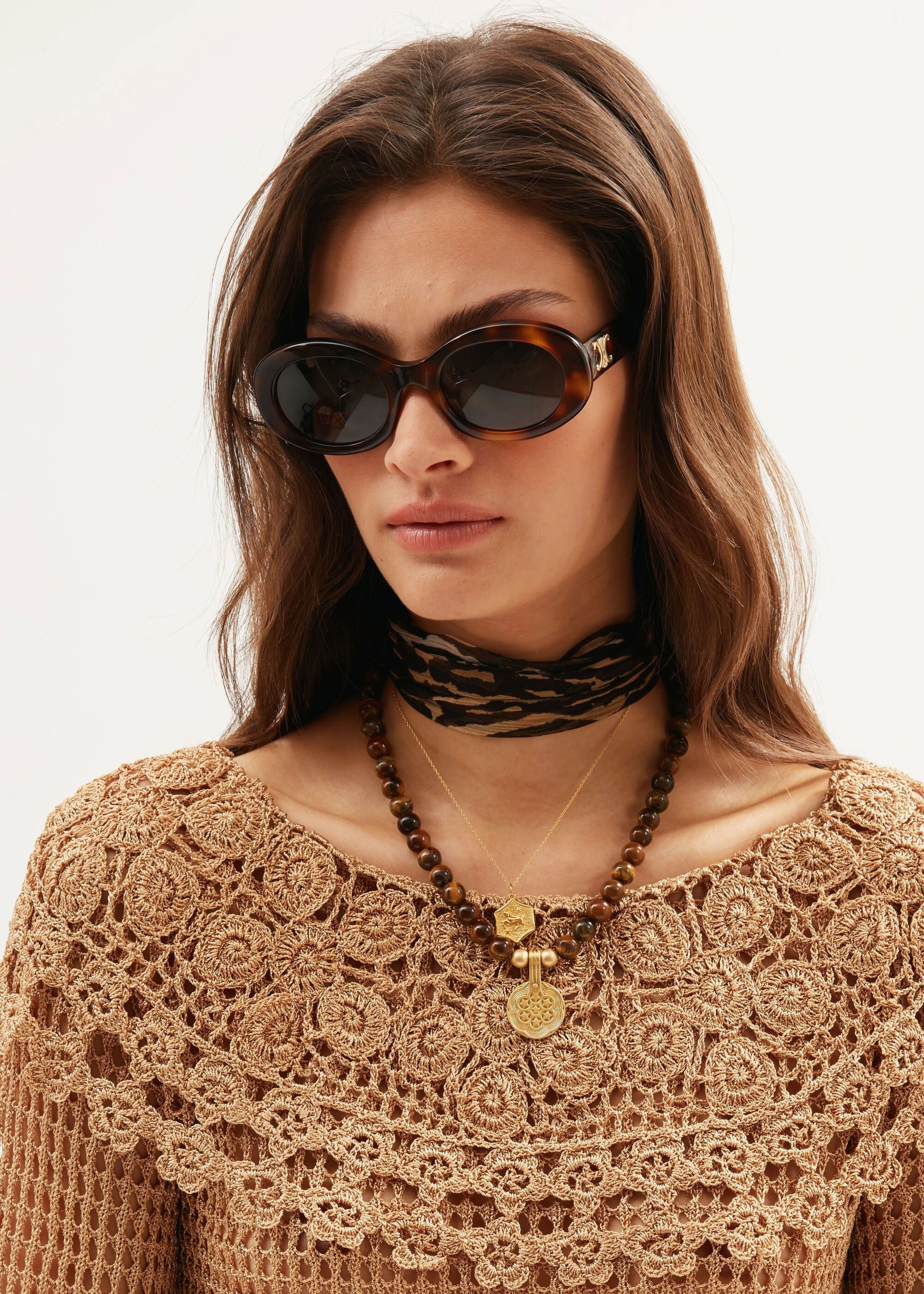 Rixo Worn at the throat with a tan crochet top and oval tortoiseshell sunglasses