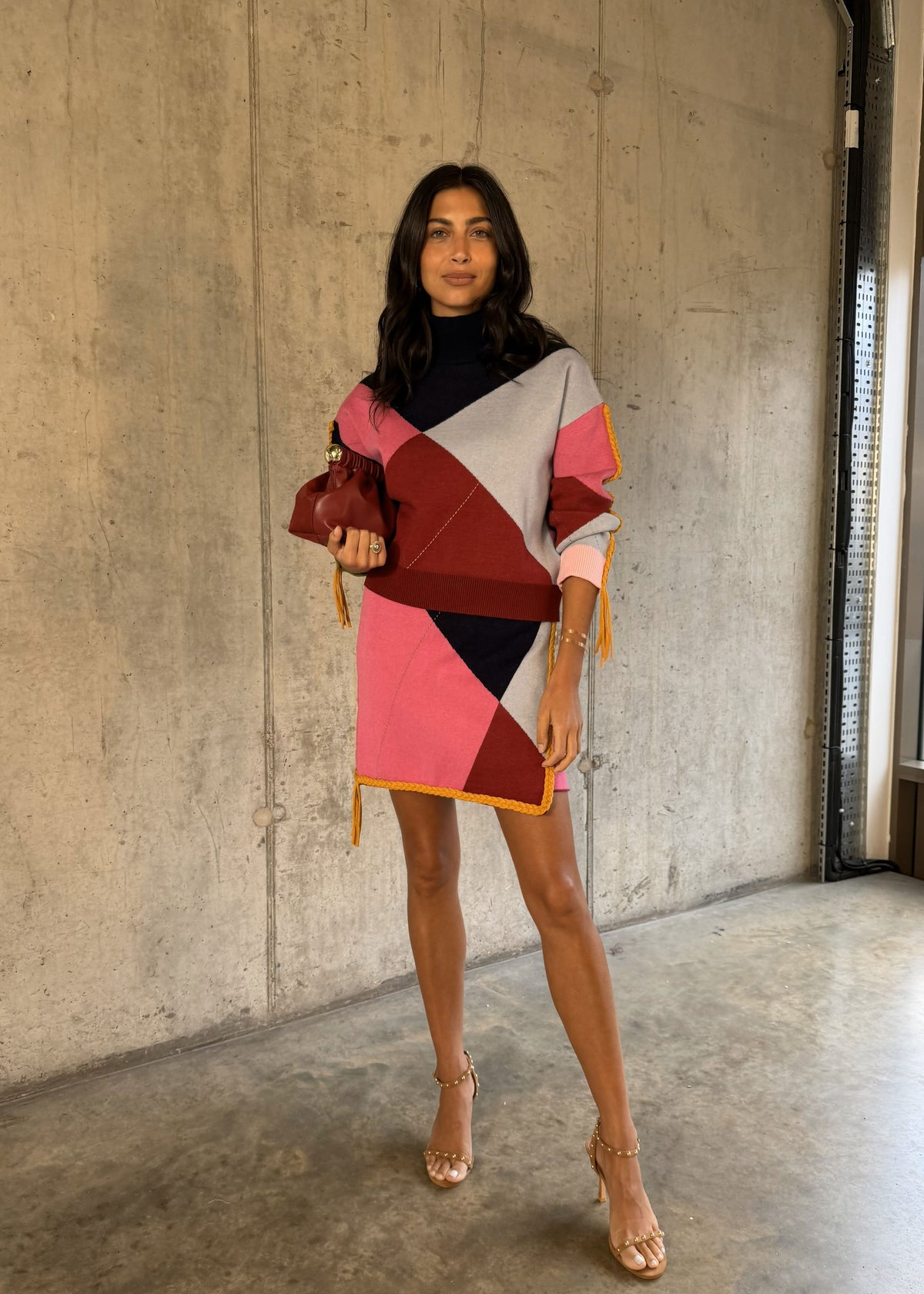 Never Fully Dressed Dark haired model in the jumper as a dress with tan heels on concrete