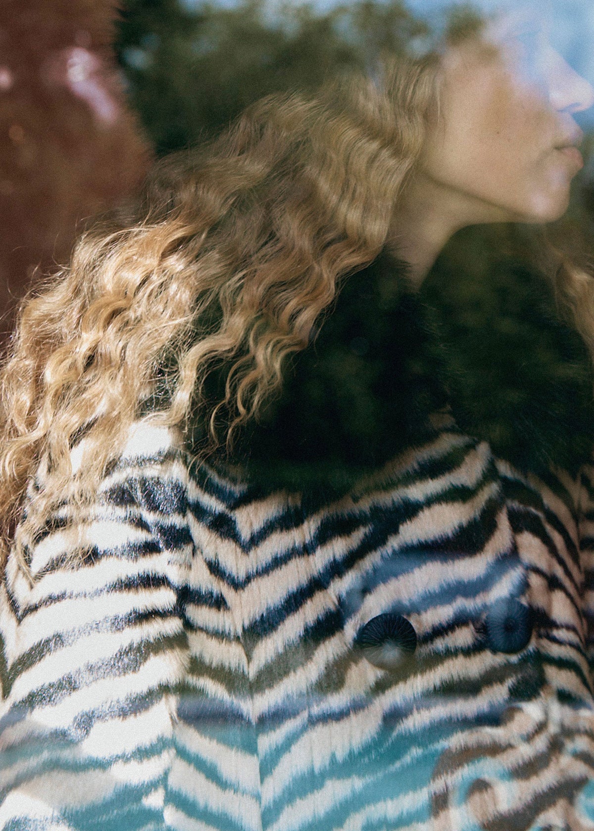 Queens of Archive Close crop through glass reflections, zebra stripes and faux fur collar at the shoulder