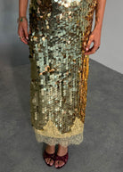 Close up of overlapping paillette sequins and cream lace hem