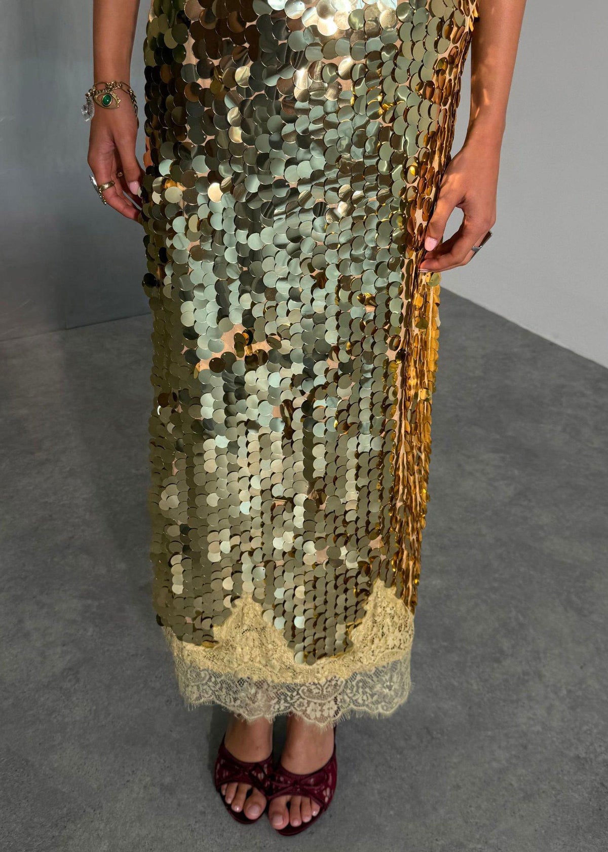 Never Fully Dressed Close up of overlapping paillette sequins and cream lace hem