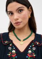 Styled with a navy embroidered peasant top and gold disc earrings