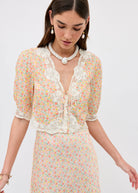 Close-up of the bodice with scalloped lace V-neck and corded tie front