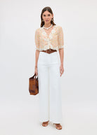 Full body styled with white wide-leg jeans and a tan suede tote