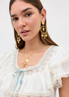 Worn with an ivory ruffled peasant top and gold cross charm necklace