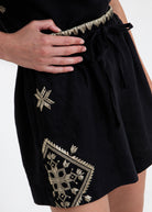 Close-up of the gold zigzag waistband, drawstring tie and diamond motif