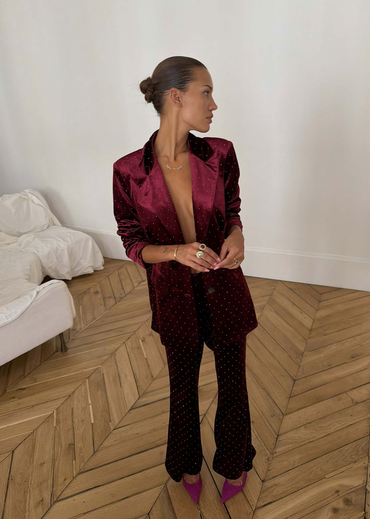 Never Fully Dressed Standing pose with hands clasped, flared velvet trousers breaking over magenta heels