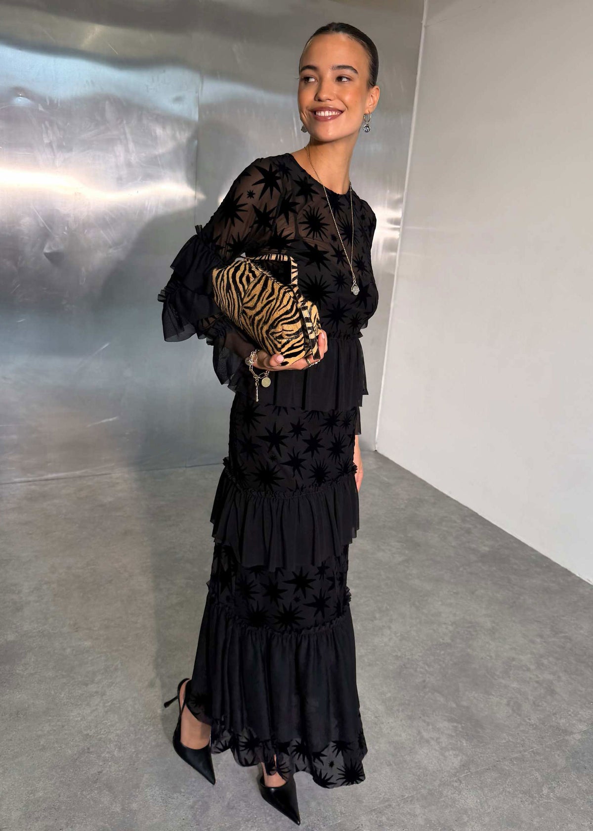 Never Fully Dressed Three quarter view with tiger print clutch and pointed black heels