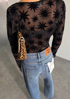 Back view of flocked star mesh above jeans with orange label