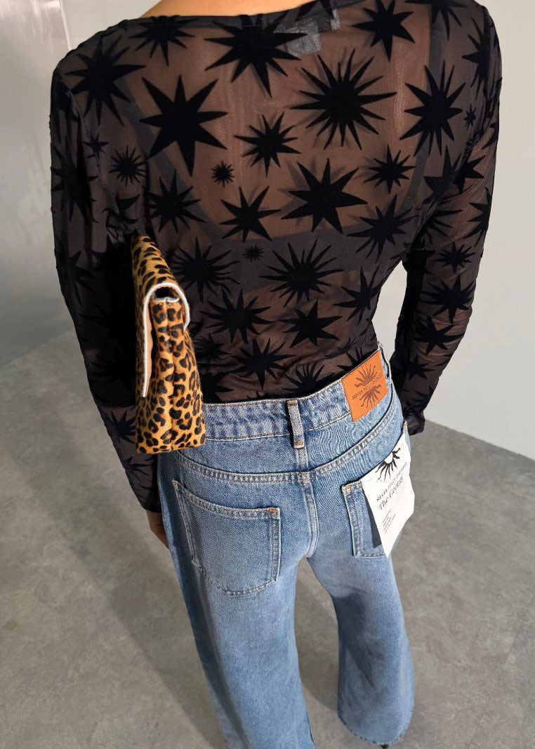 Never Fully Dressed Back view of flocked star mesh above jeans with orange label