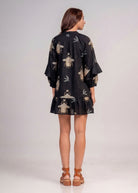 Back view of the tiered mini dress with swallow and scarab embroidery