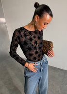 Long sleeve fit styled with light wash jeans and a leopard clutch