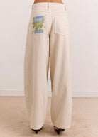 Hem detail showing the tapered ankle over black strappy sandals