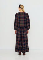 Back view, keyhole closure at the nape and full puff sleeves, worn with matching check wide-leg trousers