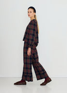 Side profile of the cropped length and gathered cuff, with wide-leg trousers and brown loafers