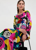 Seated pose with pink, blue and red swirls and stars across the bodice and sleeves