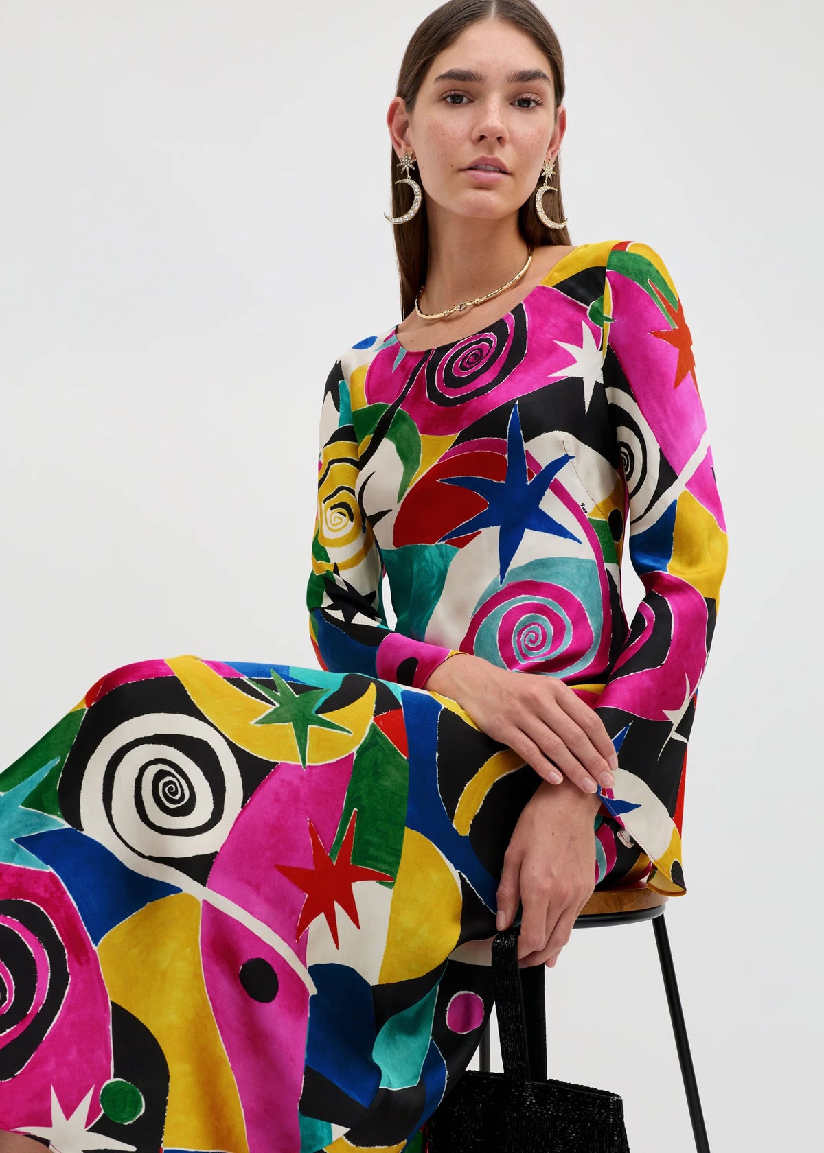 Rixo Seated pose with pink, blue and red swirls and stars across the bodice and sleeves
