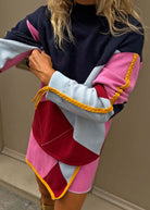 Arm lifted to show the braided gold piping along the sleeve and tassel ends