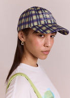 Damson Madder six-panel cap in tomboy check, blue with ecru swirl embroidery