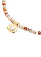 Side angle showing the gold bezel-set pendant in profile