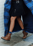 Worn with a black pleated skirt and blue check coat on a paved street