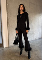 Matching fitted top with black tote and heeled ankle boots against concrete