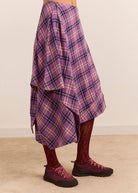Folded layers and a trailing point from the side, with burgundy tights