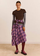 Styled with a striped tee, tied striped shirt at the waist and plum trainers