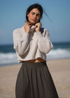 Styled with a cream cropped rib turtleneck under afternoon sun