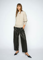 Standing front on with a slouchy oatmeal knit and pointed slingback heels