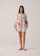 Front studio view showing relaxed silhouette and scallop shell hem