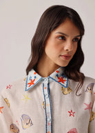 Collar detail with embroidered starfish and blue piping on placket