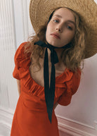 Bodice detail, ruffled scoop neckline with puff sleeves and black ribbon at the throat
