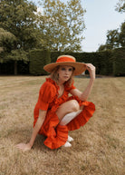 Worn outdoors with a wide-brim straw hat in a sunlit garden