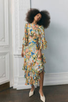 Three-quarter view, fluttering bell-sleeve ruffles and pleated chiffon tiers
