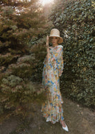 Outdoor styling shot with a wide-brim straw hat against late summer foliage