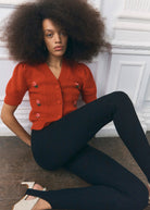 Worn with black stretch leggings and two-tone slingbacks, seated on the floor