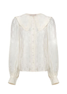 Front on white, covered button placket, ruffle-edged collar and buttoned cuffs