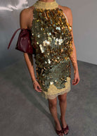 Close up of high halterneck collar and layered gold paillettes