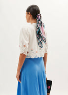Back view styled with a floral silk hair scarf and blue satin slip skirt