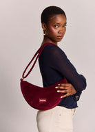 Worn on the shoulder, three-quarter back view with the strap gathered near the collar