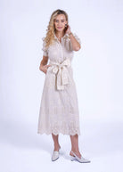 Front smile, tie-belt knotted at the waist and puff sleeves tipped with crochet