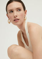 Worn on the ear showing the soft ivory tone against skin