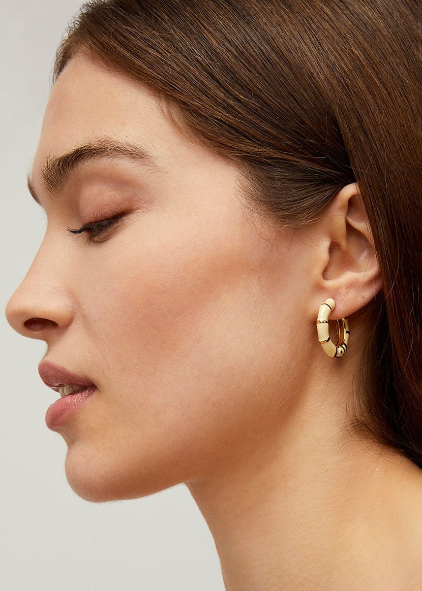 Gas Bijoux On-ear styling shot showing the ivory enamel against natural light
