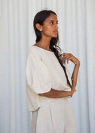 Three-quarter side view of the boxy oatmeal linen silhouette