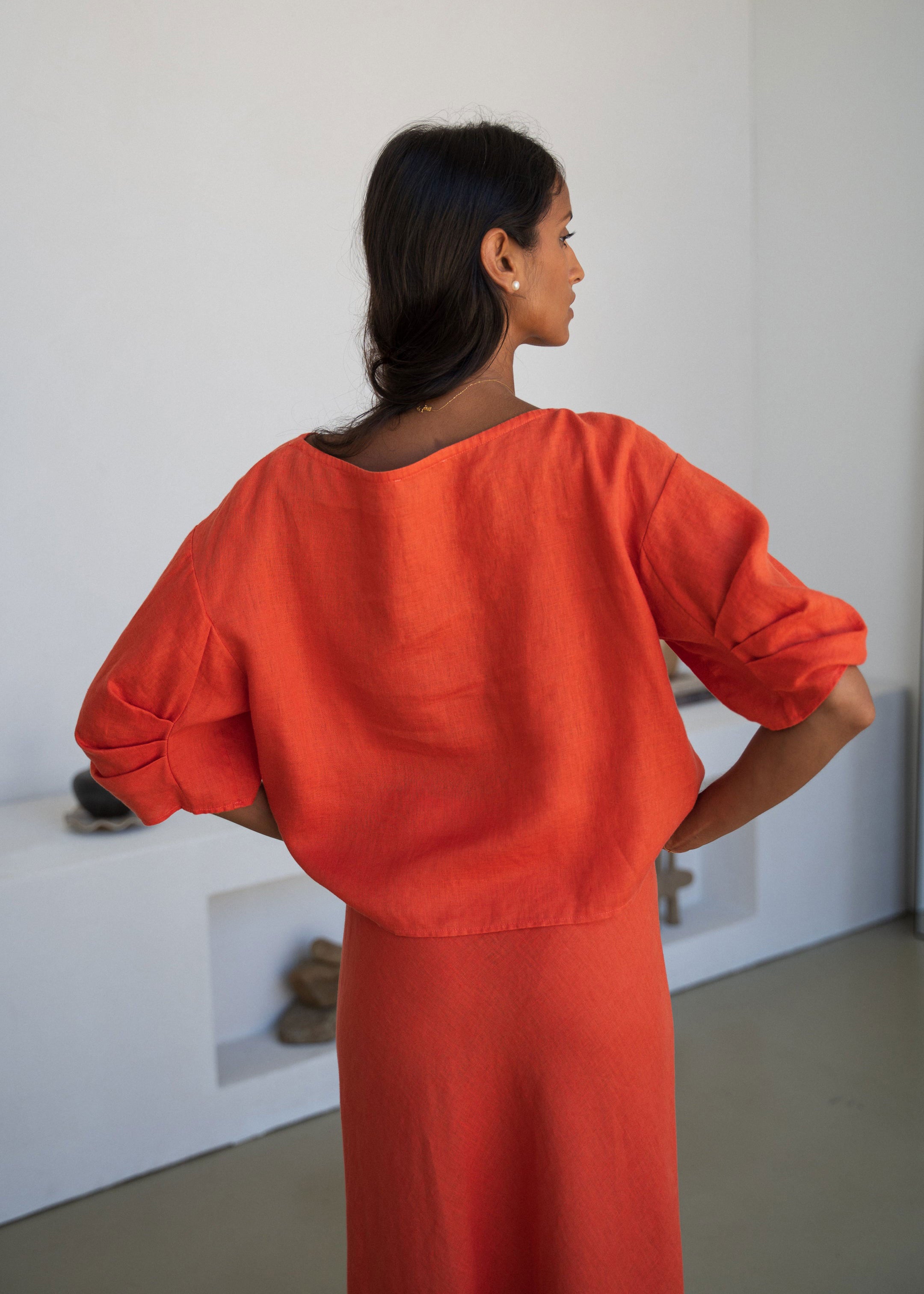 Lilly Pilly Back view, boxy cut with tuck pleats at the elbow