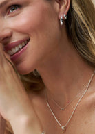 Worn doubled up in the lobe, layered silver chains and a bead pendant below